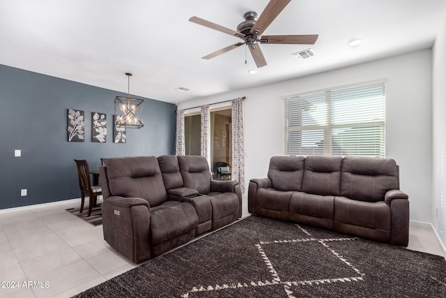 living room featuring ceiling fan with notable chandelier and light tile patterned flooring