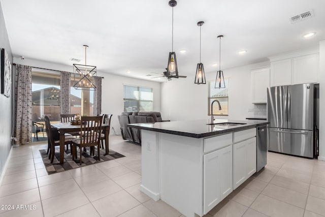 kitchen with white cabinets, sink, stainless steel appliances, and a kitchen island with sink