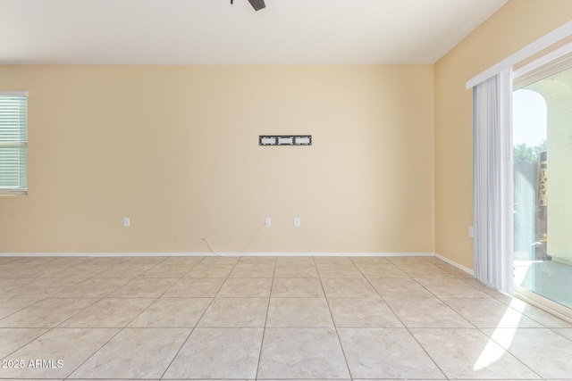 spare room with light tile patterned floors, baseboards, and a ceiling fan