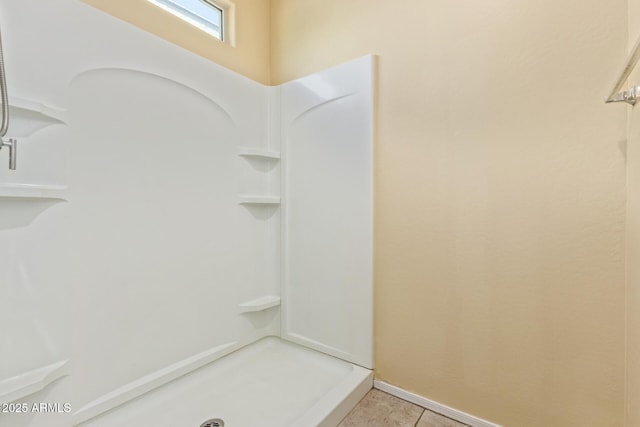 full bath featuring baseboards, a stall shower, and tile patterned floors