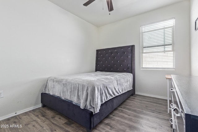 bedroom featuring dark wood-style flooring, a ceiling fan, and baseboards