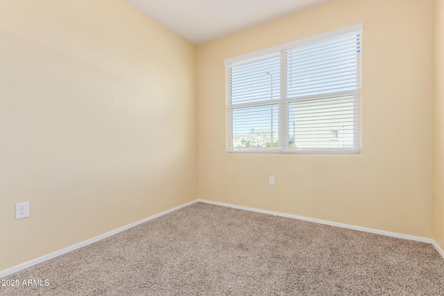 carpeted empty room featuring baseboards