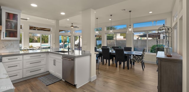 kitchen with white cabinetry, a sink, dishwasher, and wood finished floors