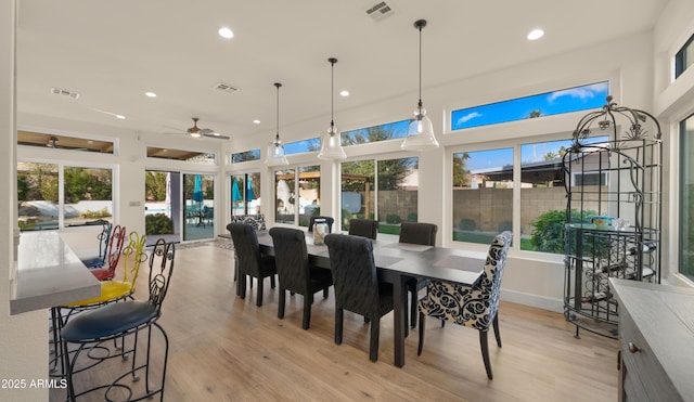 dining area with light wood-style flooring, visible vents, and recessed lighting