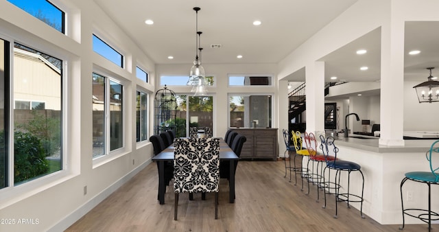 sunroom featuring a chandelier, visible vents, and a sink