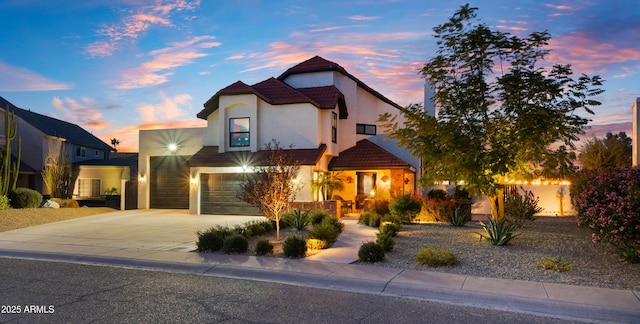 view of front of home with a tile roof, a porch, concrete driveway, and stucco siding