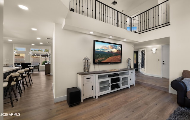 living room with dark wood-style floors, recessed lighting, visible vents, and baseboards