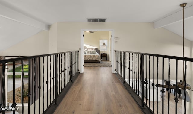 hallway with vaulted ceiling with beams, wood finished floors, and visible vents