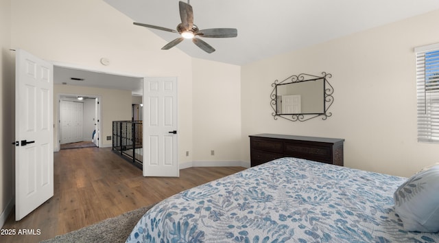 bedroom featuring visible vents, vaulted ceiling, baseboards, and wood finished floors