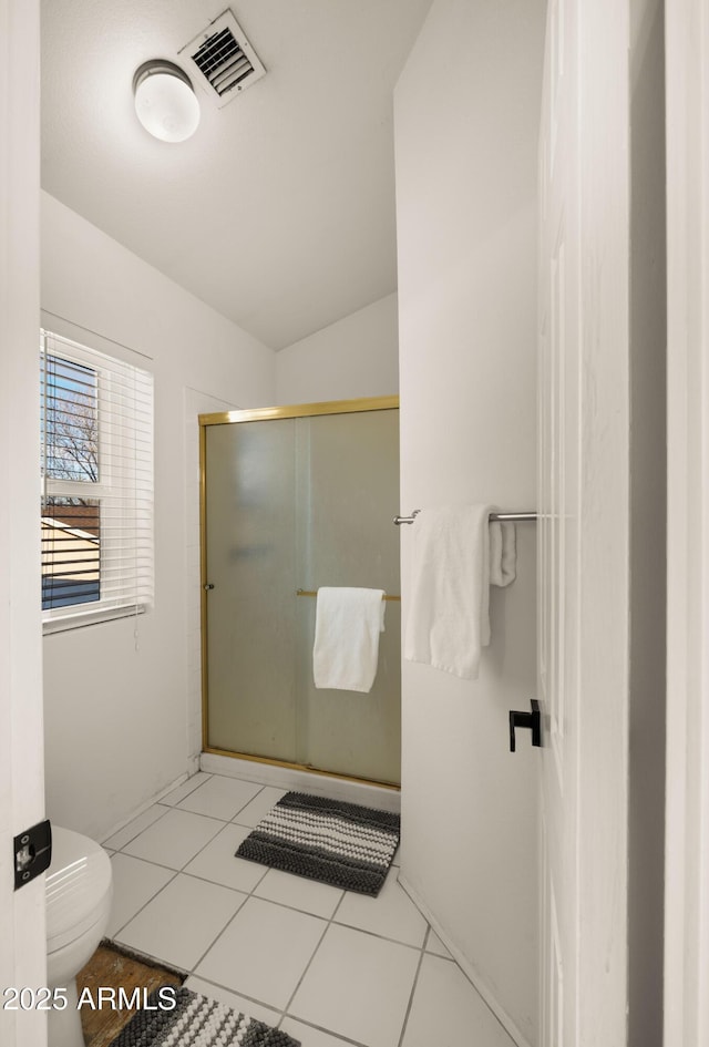 bathroom featuring lofted ceiling, tile patterned flooring, toilet, visible vents, and a shower stall