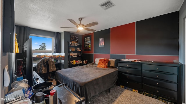 bedroom with ceiling fan, visible vents, and a textured ceiling