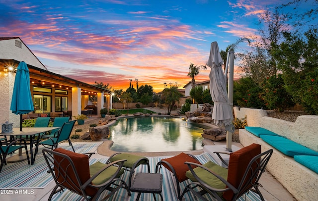 view of swimming pool with outdoor dining area, a fenced in pool, and a patio