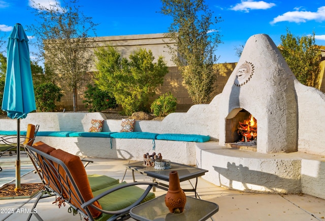 view of pool with an outdoor living space with a fireplace, a fenced backyard, and a patio