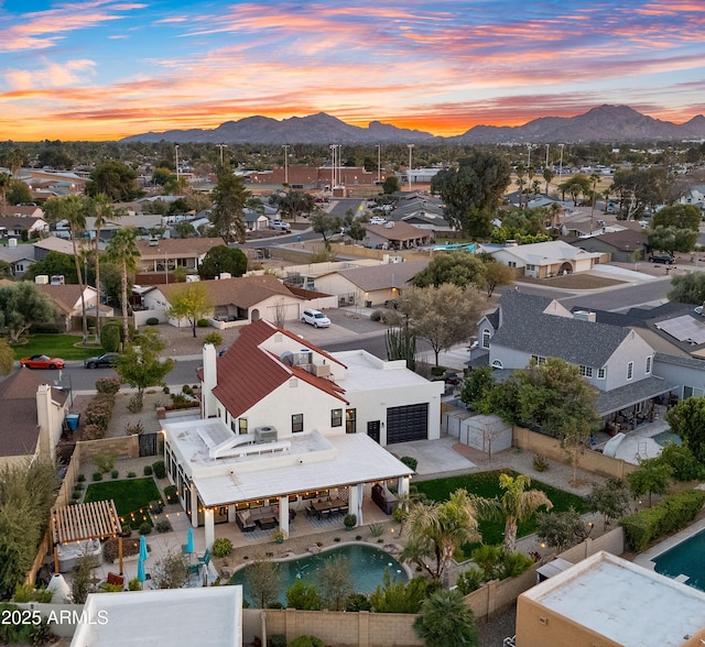 aerial view at dusk featuring a residential view and a mountain view