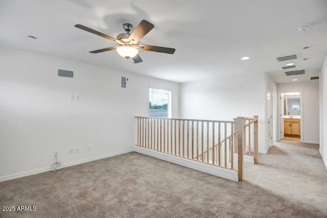 unfurnished room featuring carpet, visible vents, and baseboards