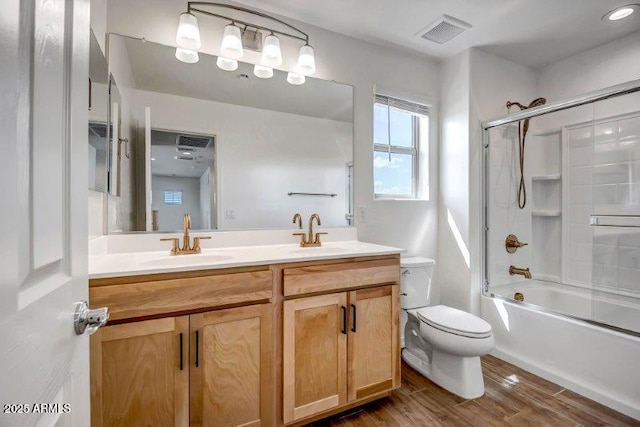 bathroom with toilet, visible vents, a sink, and wood finished floors