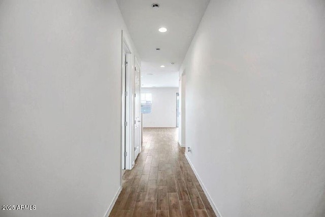 hall with baseboards, wood finished floors, and recessed lighting