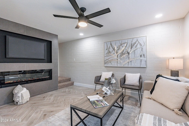 living area featuring recessed lighting, baseboards, ceiling fan, and a glass covered fireplace