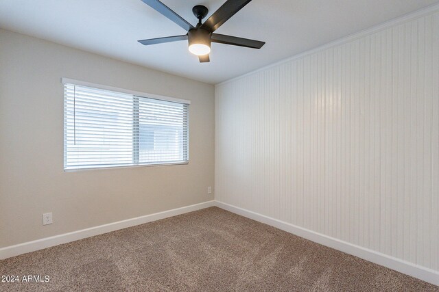 carpeted spare room with ceiling fan