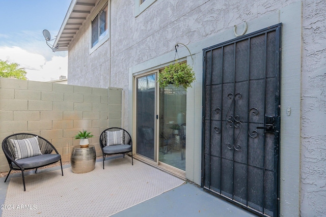 view of exterior entry featuring a patio area and stucco siding