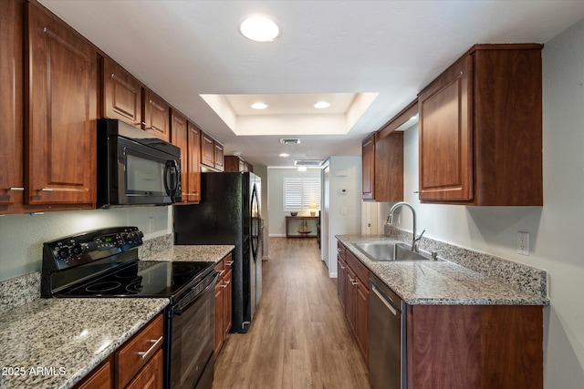 520 S Greenfield Rd Unit 7, Mesa, AZ 85206 - kitchen with black appliances, a tray ceiling, light wood-style flooring, light stone counters, and recessed lighting
