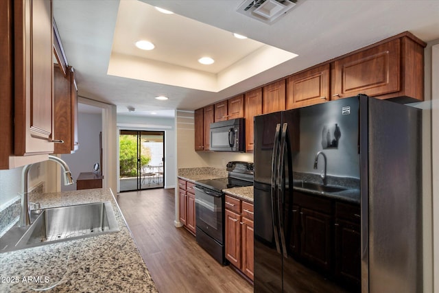 520 S Greenfield Rd Unit 7, Mesa, AZ 85206 - kitchen with black appliances, a raised ceiling, wood finished floors, recessed lighting, and brown cabinets