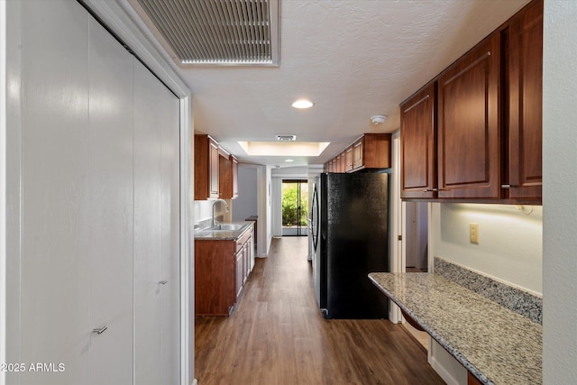 520 S Greenfield Rd Unit 7, Mesa, AZ 85206 - kitchen with freestanding refrigerator, wood finished floors, light stone counters, recessed lighting, and brown cabinets