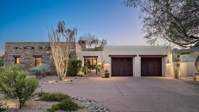 pueblo-style home with a garage