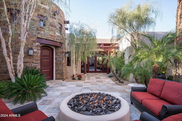 view of patio with an outdoor living space with a fire pit and french doors