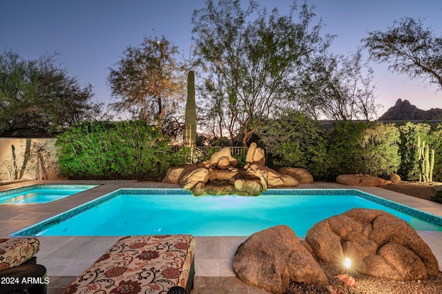 pool at dusk with a jacuzzi