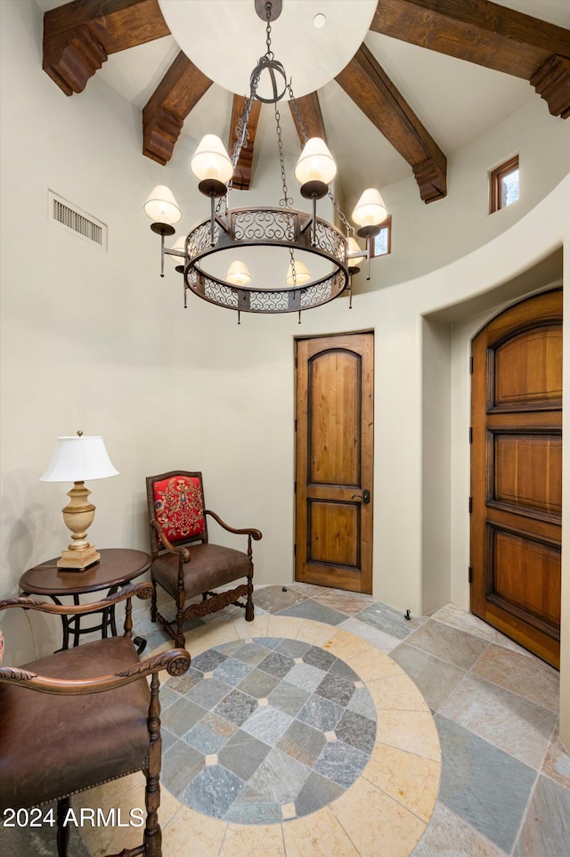 living area featuring beamed ceiling and a high ceiling