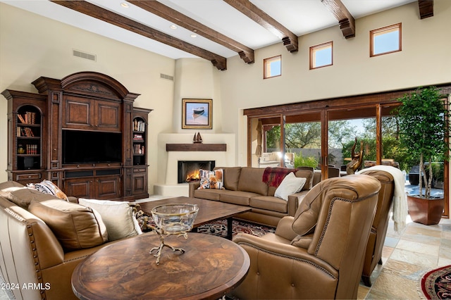 living room with a high ceiling and beamed ceiling