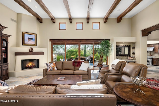 living room featuring beamed ceiling and a high ceiling