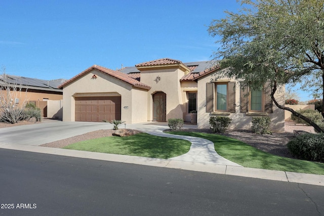 mediterranean / spanish home featuring solar panels, a tile roof, concrete driveway, stucco siding, and a garage