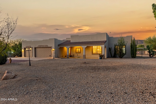 southwest-style home with a porch and a garage