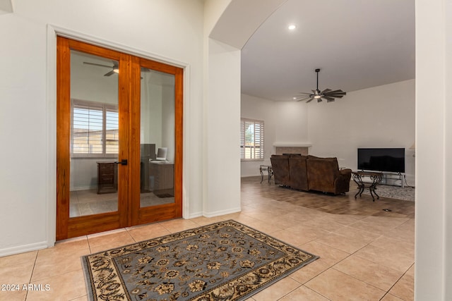 interior space with light tile patterned floors, ceiling fan, french doors, and plenty of natural light