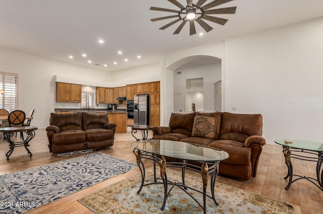 living room with ceiling fan, light hardwood / wood-style flooring, and sink