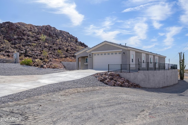 view of front of home featuring a garage, fence, concrete driveway, and stucco siding