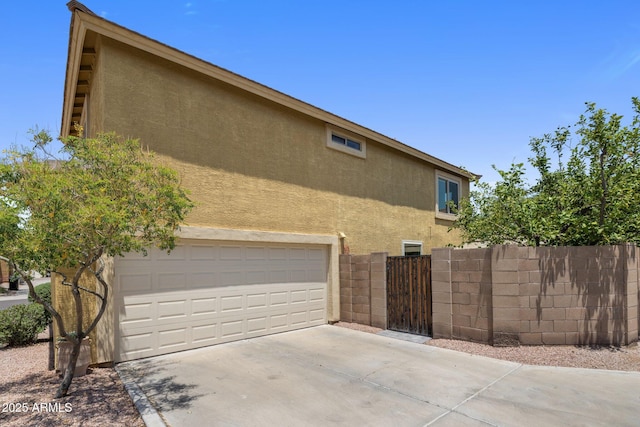 21813 N 40th Way, Phoenix, AZ 85050 - view of home's exterior featuring stucco siding, a garage, and concrete driveway