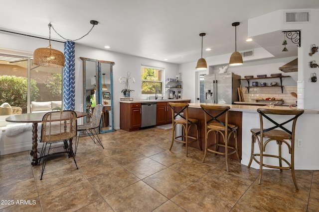 21813 N 40th Way, Phoenix, AZ 85050 - kitchen with stainless steel appliances, light countertops, open shelves, decorative backsplash, and a kitchen bar