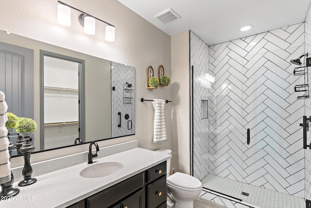 full bathroom with toilet, vanity, a shower stall, and visible vents