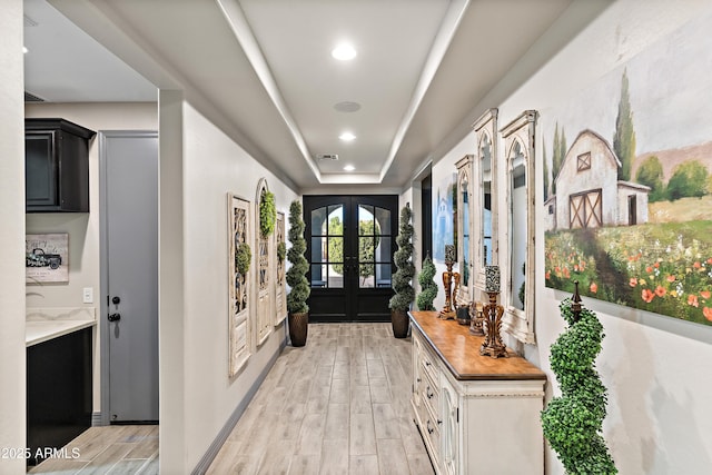 doorway to outside with french doors, recessed lighting, a raised ceiling, visible vents, and light wood-style flooring