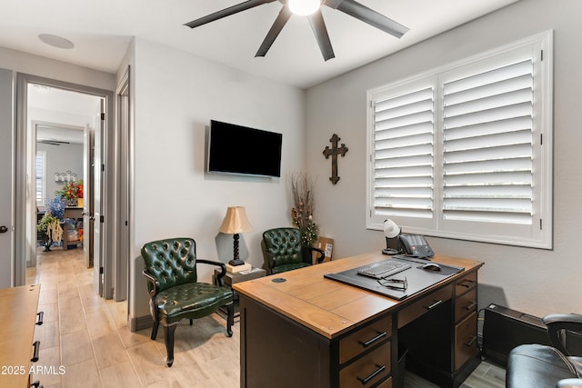 home office featuring light wood-style floors and a ceiling fan