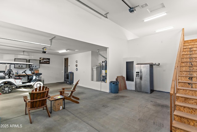 garage featuring visible vents, a garage door opener, gas water heater, and stainless steel fridge with ice dispenser