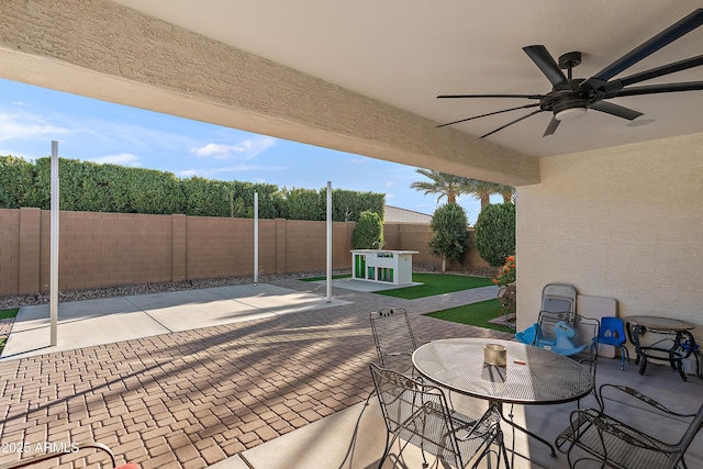 view of patio featuring ceiling fan, outdoor dining area, and a fenced backyard