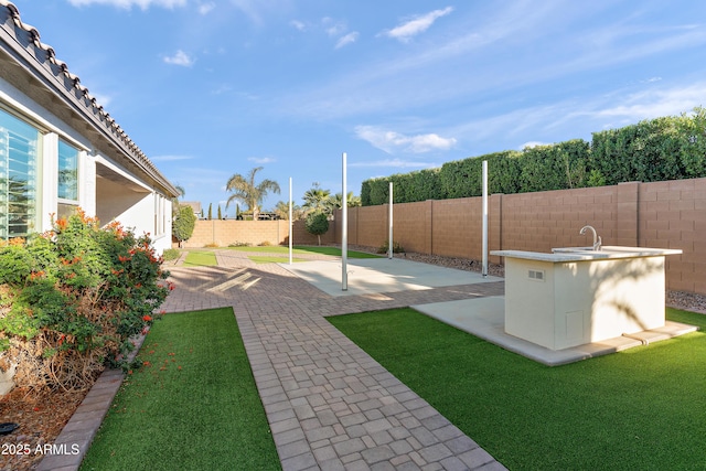 view of yard with a patio area, a sink, and a fenced backyard