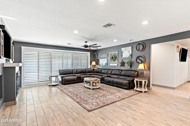 living room featuring light wood-type flooring, visible vents, a ceiling fan, and recessed lighting