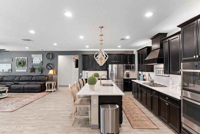 kitchen with open floor plan, stainless steel appliances, a sink, and visible vents