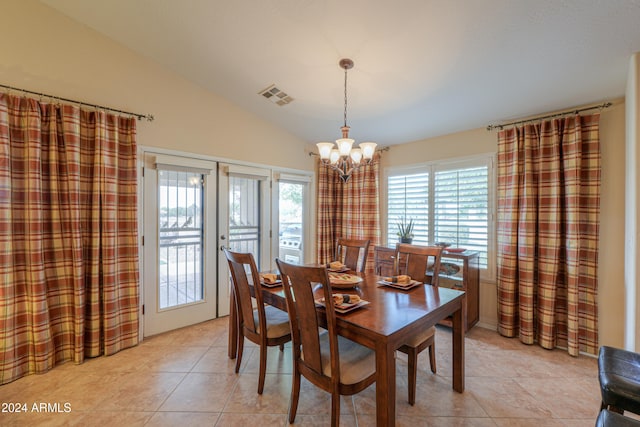 tiled dining area with a chandelier, french doors, and vaulted ceiling