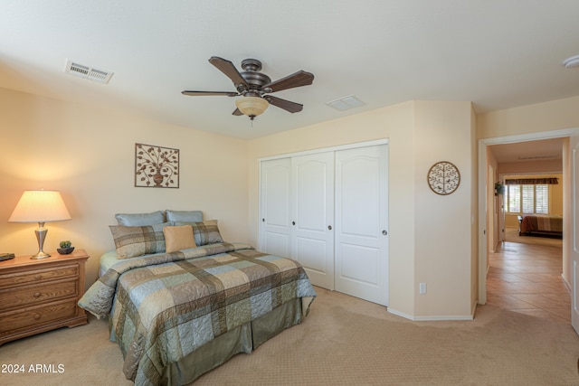 carpeted bedroom with ceiling fan and a closet